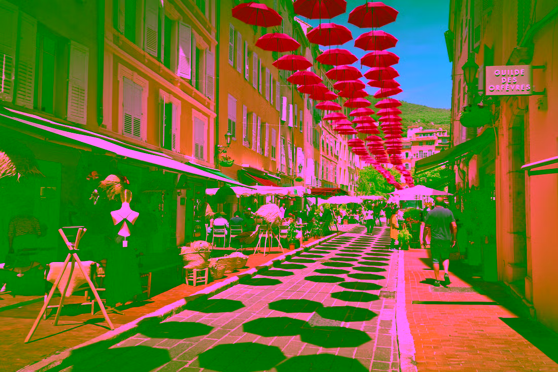 Narrow street in Grasse with pink umbrellas overhead, historic old town and perfume capital atmosphere, Provence landscape, Grasse Gourdon Tourrettes-sur-Loup shore excursion from Cannes