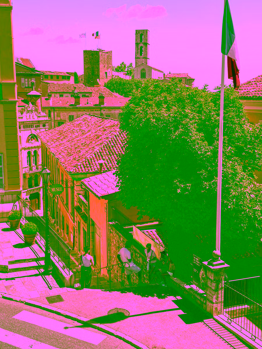 Grasse old town street with cathedral bell tower and French flag — shore excursion from Cannes